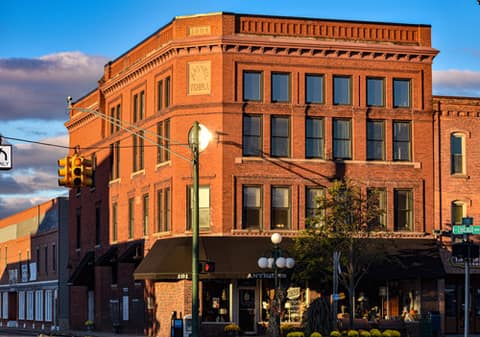 A three-story historic brick building on a downtown Tecumseh corner at sunset