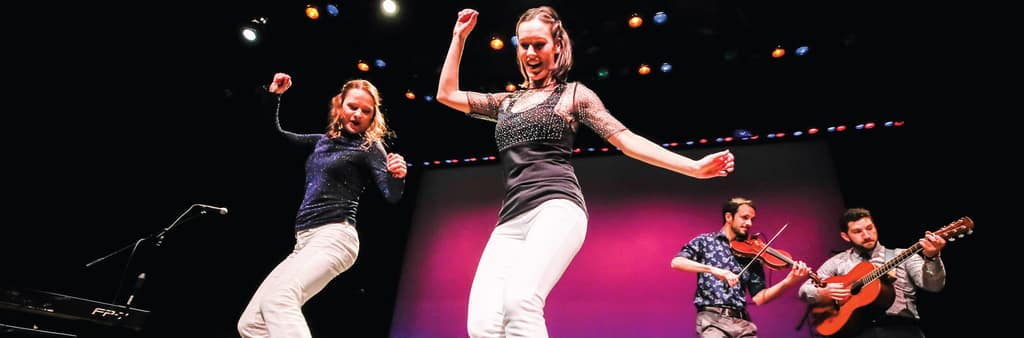 Dancers and a guitarist performing on stage at the Tecumseh Center for the Arts