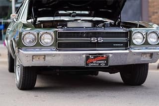 A classic Chevelle SS with its hood up at the car show