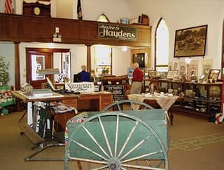 Exhibits inside the Tecumseh Historical Museum, including a wagon wheel and period furniture