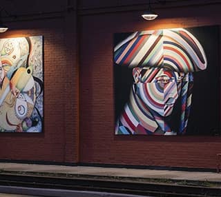 Colorful portrait murals on a brick wall in downtown Tecumseh